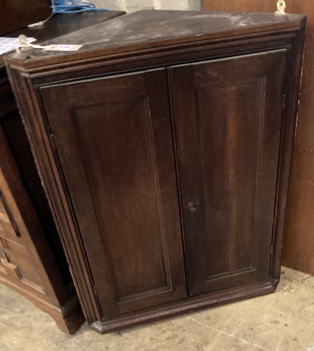 A George III oak hanging corner cupboard, width 66cm, depth 30cm, height 86cm